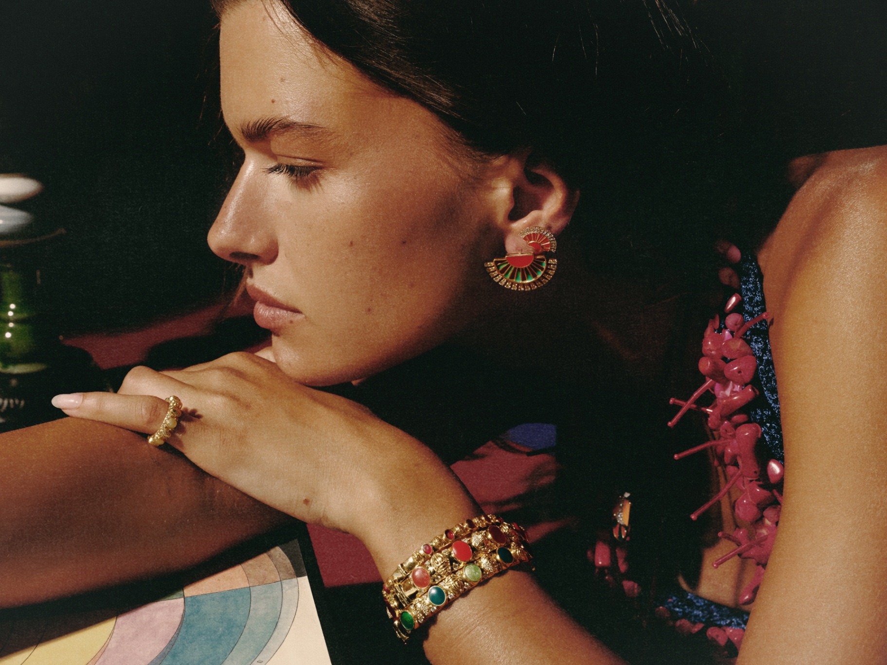 Profile with red-and-green fan earring and stacked bangles
